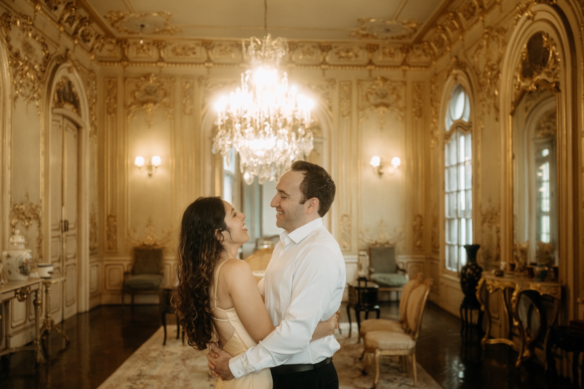 Marcia and Alex beneath a chandelier in a historic Lima interior